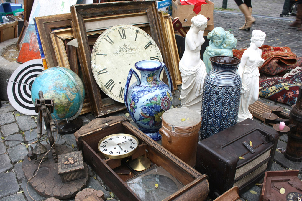 divers objets anciens posés au sol dans une brocante